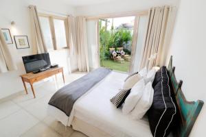 a bedroom with a large bed and a television at The Villas Umalas in Canggu