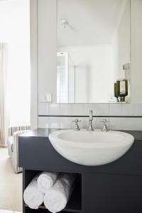 a bathroom with a sink and a mirror and towels at Plough Hotel in Melbourne