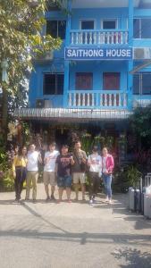 a group of people standing in front of a blue building at Saithong House in Chiang Mai