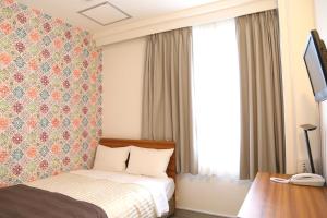 Habitación de hotel con cama y ventana en Tokyo Ueno New Izu Hotel en Tokio