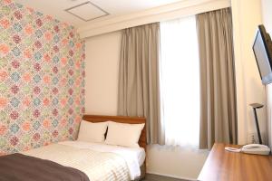 Giường trong phòng chung tại Tokyo Ueno New Izu Hotel