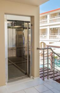 eine Glastür in einem Gebäude mit Balkon in der Unterkunft Natalie Hotel in Laganas
