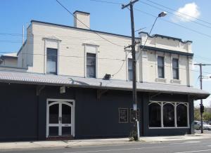 un edificio azul y blanco en la esquina de una calle en Plough Hotel, en Melbourne