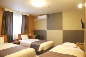a hotel room with two beds and a window at Tokyo Ueno New Izu Hotel in Tokyo +20 photos