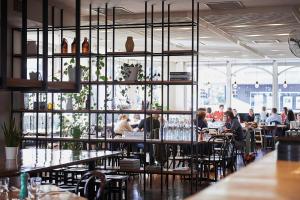a group of people sitting at tables in a restaurant at Plough Hotel in Melbourne