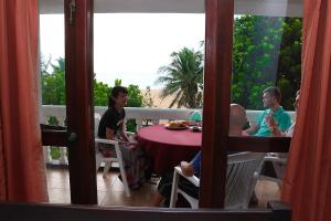 a group of people sitting around a table on a balcony at Topaz Beach Hotel in Negombo