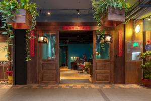 Zugang zu einem Restaurant mit Türen und Pflanzen in der Unterkunft Cho Hotel in Taipeh