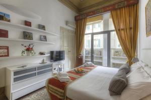 a bedroom with a bed and a tv and a window at Duomo Suite Central Home in Florence