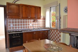 a kitchen with wooden cabinets and a wooden table at Zia Peppina in Tertenìa +12 photos