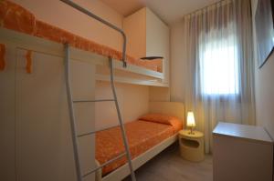 a small room with two bunk beds and a desk at Appartamenti Alisei e Cristina in Bibione