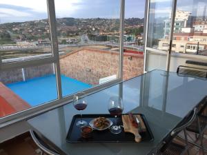 una mesa con un plato de comida y dos copas de vino en Atiko 15, en Gijón