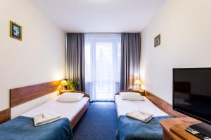 a hotel room with two beds and a flat screen tv at Albatros Medical SPA in Mielno +25 photos