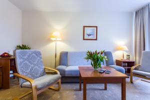 ein Wohnzimmer mit 2 Stühlen, einem Sofa und einem Tisch in der Unterkunft Albatros Medical SPA in Mielno