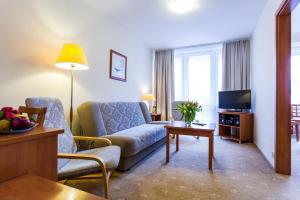 a living room with a couch and a tv at Albatros Medical SPA in Mielno