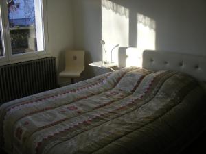a bed with a quilt on it in a bedroom at au sapin des vosges in Saint-Étienne-lès-Remiremont