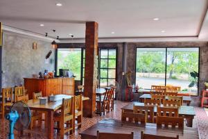KP Mountain Beach في بران بوري: مطعم بطاولات وكراسي خشبية ونوافذ