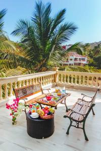 a table with plates of food on a balcony at SaffronStays La Casa Maestro, Kashid - spanish-style luxury villa near Kashid Beach in Kashid