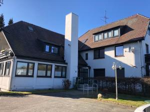 ein weißes Haus mit schwarzem Dach in der Unterkunft Kuschelkajüte by WellenRausch in Travemünde