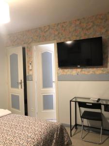 カルパントラにあるVilla hortensiaのベッドルーム1室(ベッド1台、壁掛けテレビ付きのデスク付)