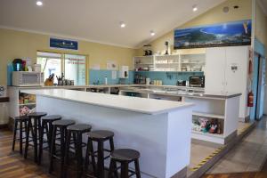 a kitchen with a bar with stools around it at Hervey Bay Flashpackers in Hervey Bay