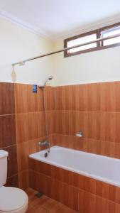 
a bathroom with a tub, toilet and shower stall at Arra Lembah Pinus Ciloto in Puncak
