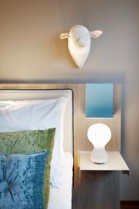 a white bed with a lamp on top of it at Clarion Hotel The Hub in Oslo