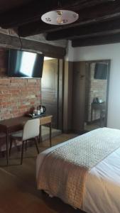 a bedroom with a bed and a desk and a tv at Agriturismo San Gallo in Strassoldo