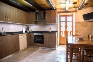 a kitchen with wooden cabinets and a wooden table with a tableablish at Casa Katton in Etxalar
