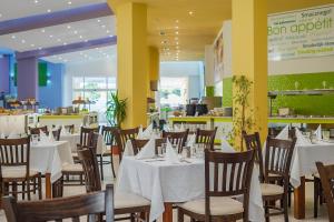 a dining room with white tables and chairs at Hotel Forest Beach in Primorsko