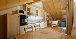 a kitchen and dining room with a table and chairs at La Casa al Noce in Mezzana