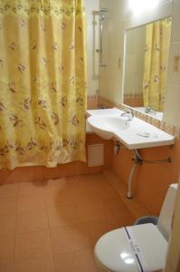 La salle de bains est pourvue d'un lavabo, de toilettes et d'un miroir. dans l'établissement Gostiniy Dvor, à Vinnytsia