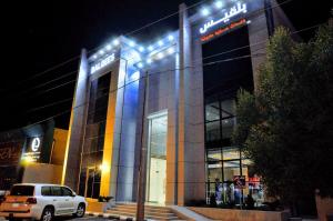 ein Auto, das nachts vor einem Gebäude parkt in der Unterkunft منازل بلقيس للشقق المخدومة فرع الشفاء in Ha'il