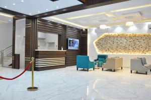 a lobby of a hotel with chairs and a table at منازل بلقيس للشقق المخدومة فرع الشفاء in Hail