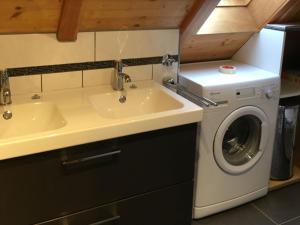 a bathroom with a sink and a washing machine at Pension Haus Rose in Oberharmersbach