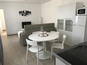 a white table and chairs in a kitchen with a couch at Appartement proche Mer avec appartement au 1er etage et appartement 1 au 2eme etage avec baignoire in Berck-sur-Mer