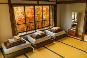 
a bed room with two beds and two windows at Onsen Guesthouse HAKONE TENT in Hakone
