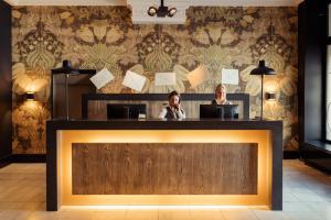 two women sitting at a counter in a restaurant at Post-Plaza Hotel & Grand Café in Leeuwarden