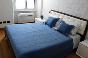 um quarto com uma cama com lençóis azuis e uma janela em Perfect apartment Como em Como