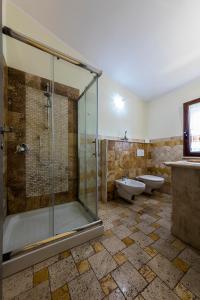 y baño con ducha, aseo y lavamanos. en Sardinia for you, en Oristano