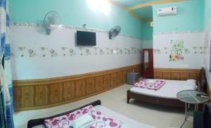 a room with two beds and a flat screen tv at Gia Long Motel in Long Hai