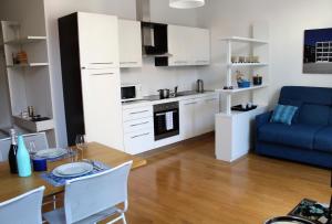 a kitchen and living room with a table and a blue couch at Perfect apartment Como in Como