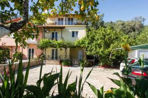 a building with a lot of trees in front of it at Kefalas Apartments in Parga