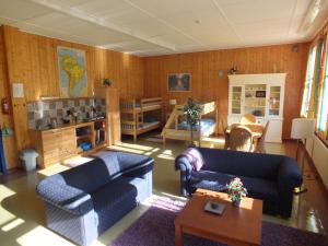 uma sala de estar com dois sofás azuis e uma mesa em Henseid Skole em Hennseid