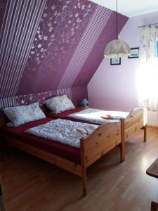 una camera con due letti e una parete viola di Pension-Stürrad a Neuharlingersiel