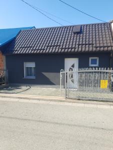a blue house with a fence next to a street at Apartman Bilivano in Zagreb