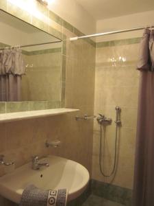 een badkamer met een wastafel en een douche met een spiegel bij Kolios View Studios in Kolios