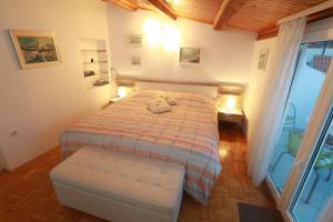 a bedroom with a bed and a chair and a window at Apartments Pyros in Piran