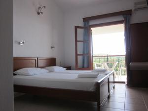 een slaapkamer met een bed en een groot raam bij Kolios View Studios in Kolios