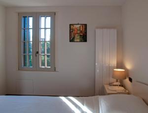 una camera bianca con un letto e una finestra di Villa Contarini B&B a Lido di Venezia