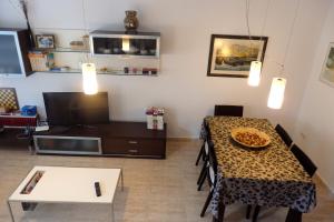 a living room with a table and a television at MEDDAYS CHALET EUCALIPTUS 6 in Miami Platja